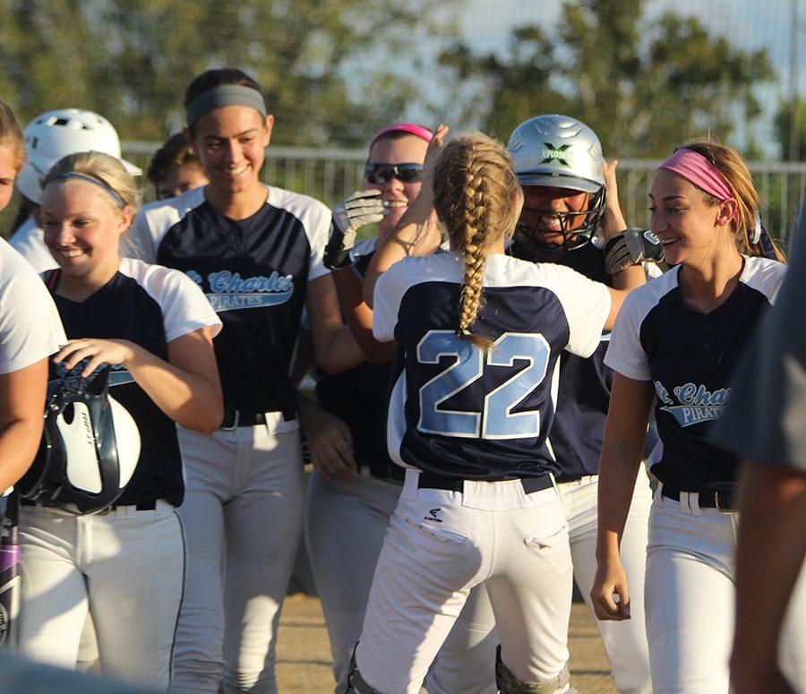 The softball team greets freshman Kylie Swinney after hitting an inside-the-park home run against St. Charles West in Districts on Oct. 5