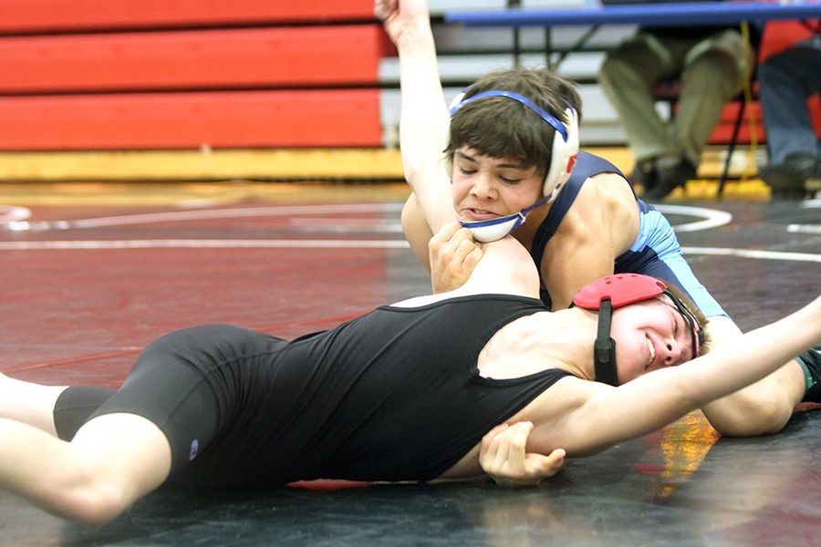Sophomore Benjamin Bohr pins his opponent to the ground during this teams tourney at Liberty