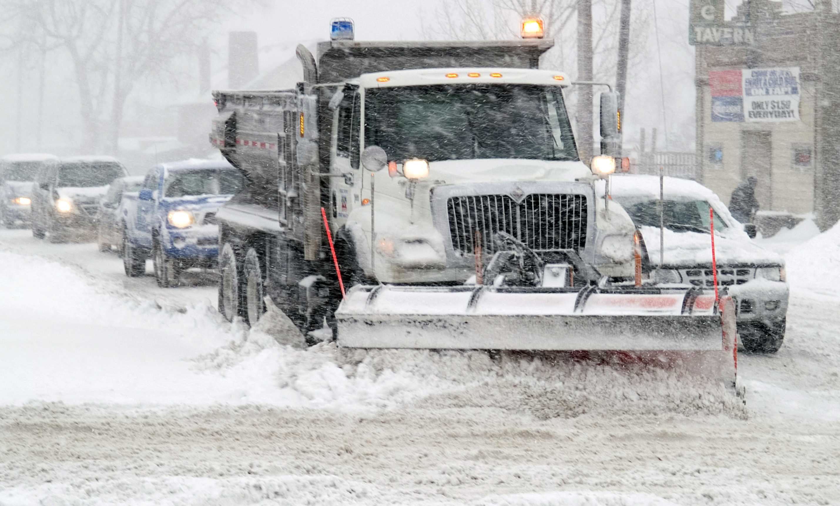 A snow plow clears off the streets for drivers to continue on the roads as snowy conditions continue.