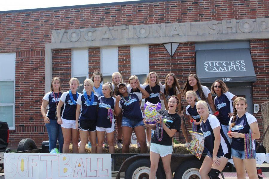 The softball team poses on their float, awaiting the start of the parade.