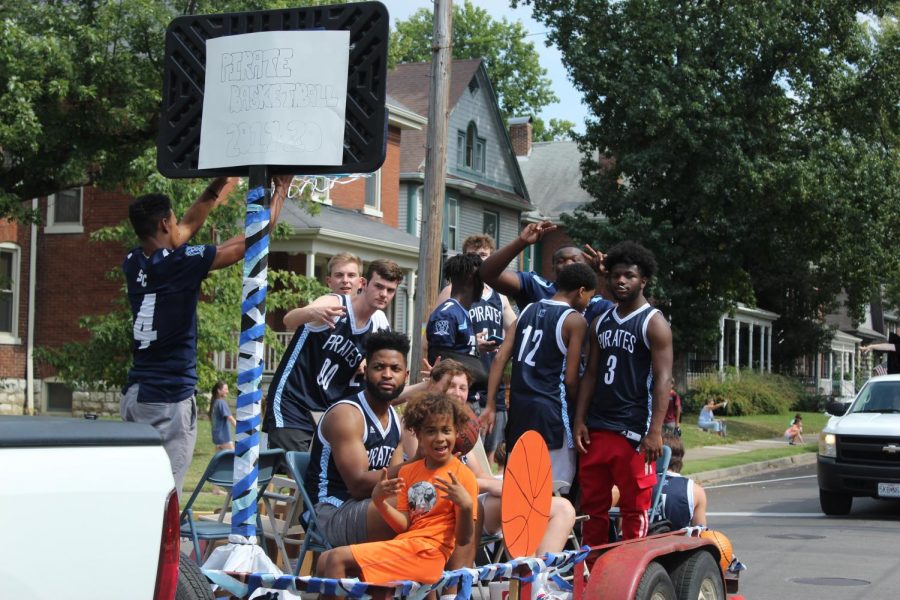 The basketball team rides their float in the parade.