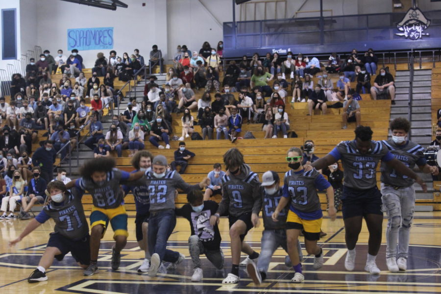 The Varsity football team busts down into the splits.