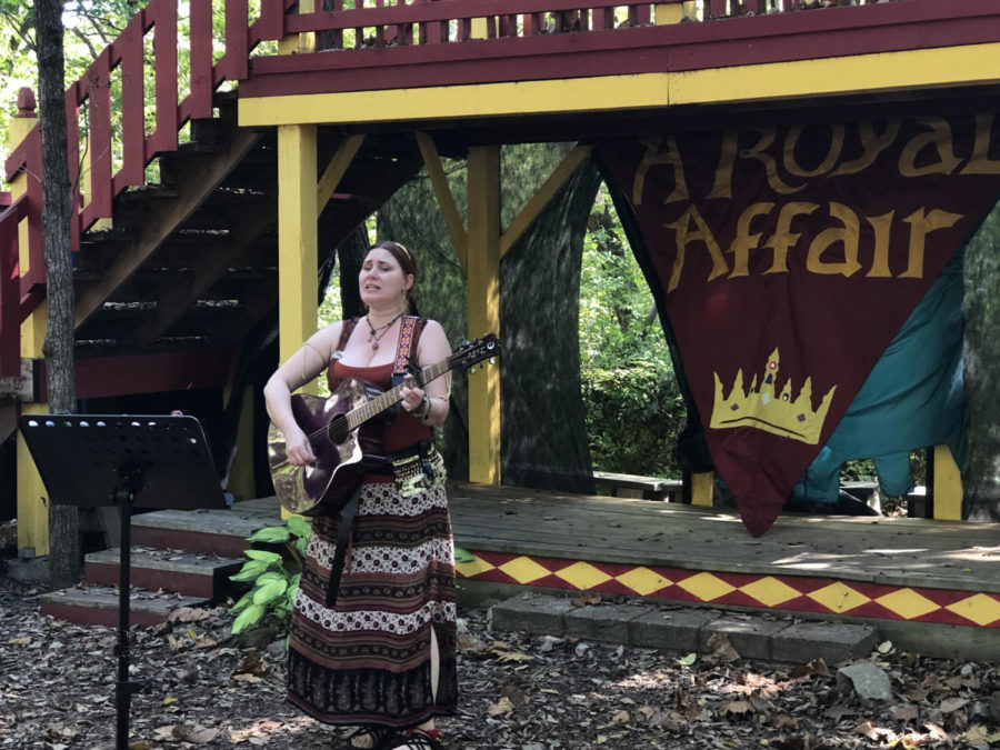 This Renaissance Faire performer strums her heart out on stage.