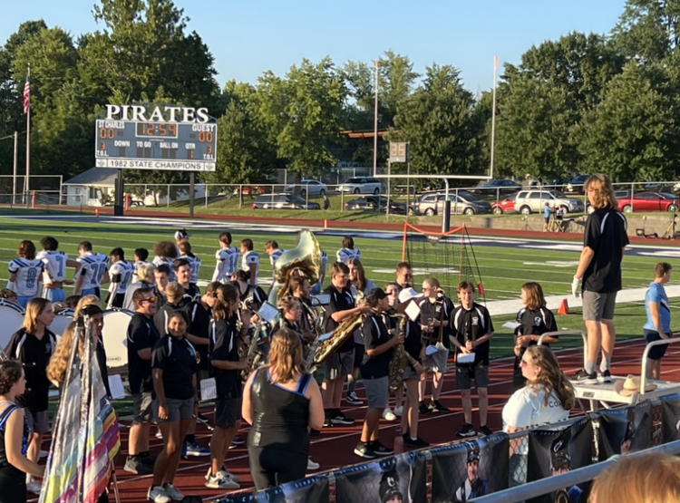 The marching band plays music before the football game begins.