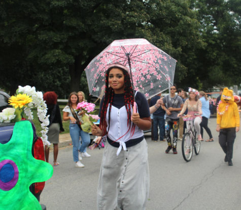 Isabella Lathen walks  and stuns the crowd with her flower umbrella. Creative writing and art club combined their floats for the annual homecoming parade and their theme was flowers.