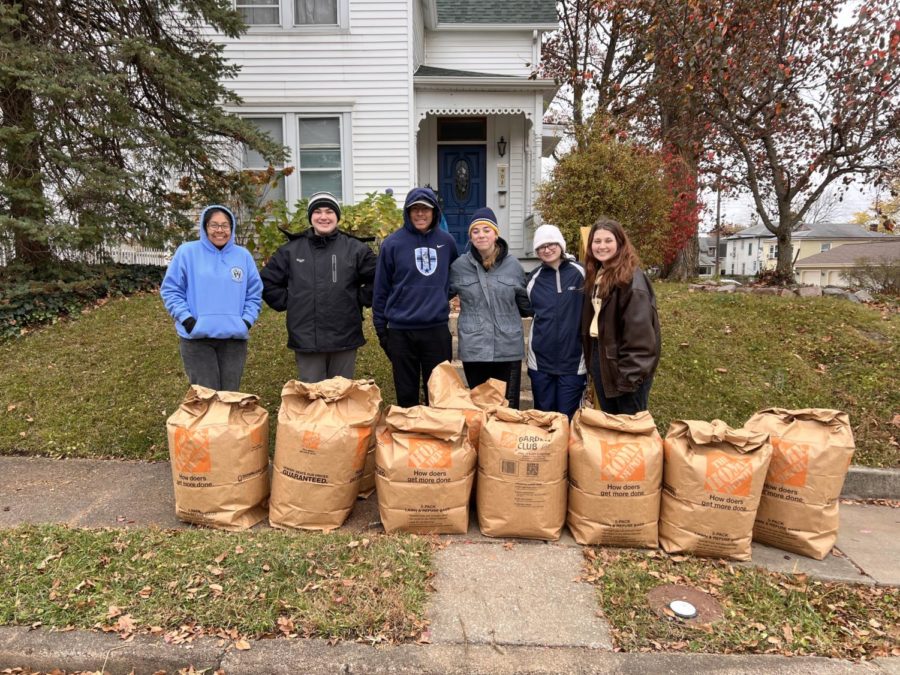 The Key Club Raking team smiles for a picture after successfully raking a yard. 