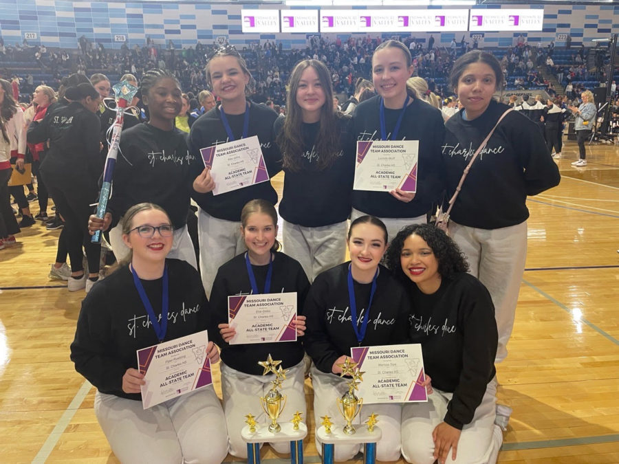 Dance line poses with their trophies and certificates. 