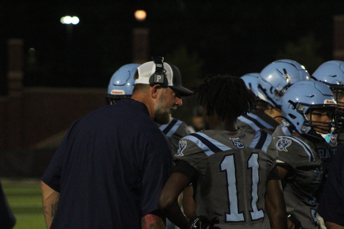Coach Dan Mcmullen giving DMonte Bagby in game advice on the sideline. 