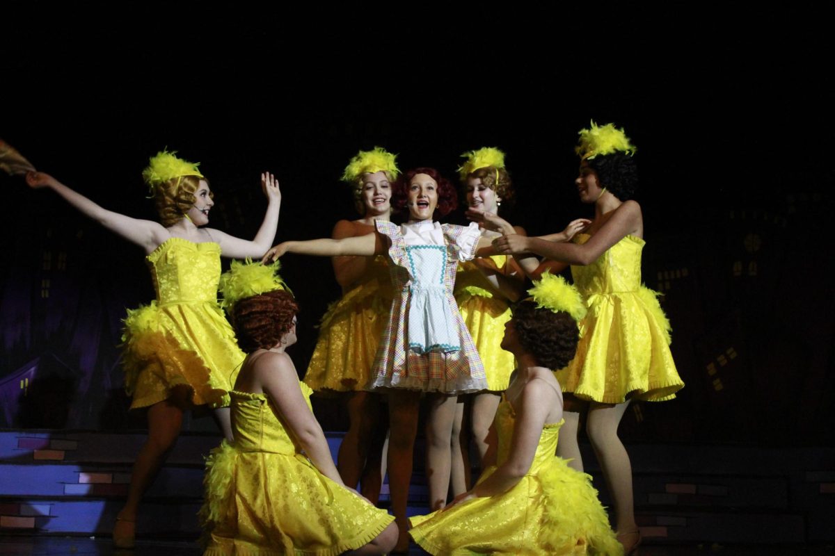 The Hot Box Girls help senior Ana McAlister (Adelaide) change outfits during “A Bushel and a Peck.”
