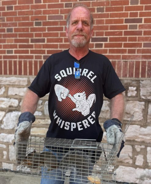 Lead Custodian Tom Wright holds his prize squirrel after capturing it.