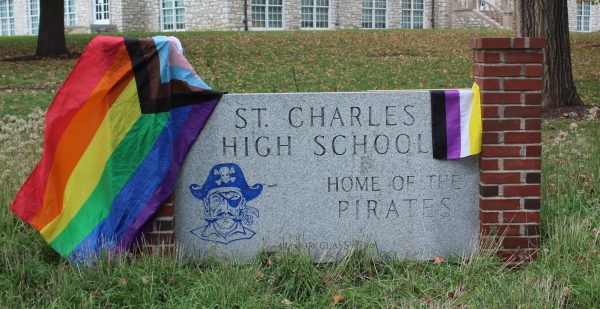 The sign outside of St. Charles High, adorned with a progress pride flag and nonbinary pride flag.