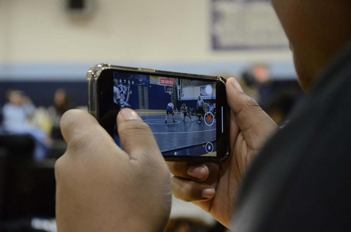 Student records the match in front of them at the Blue and White Night.