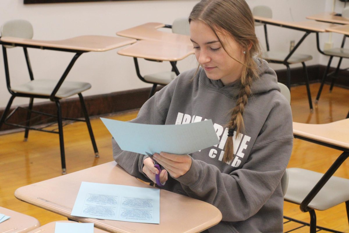 In Mrs. Kohr’s room on Jan. 31, senior Charlotte Anderson cuts cards for the Student of the Month nominations. She was called to AIP that day by Mrs. Kohr to finish the cards and give them to the recipients.
