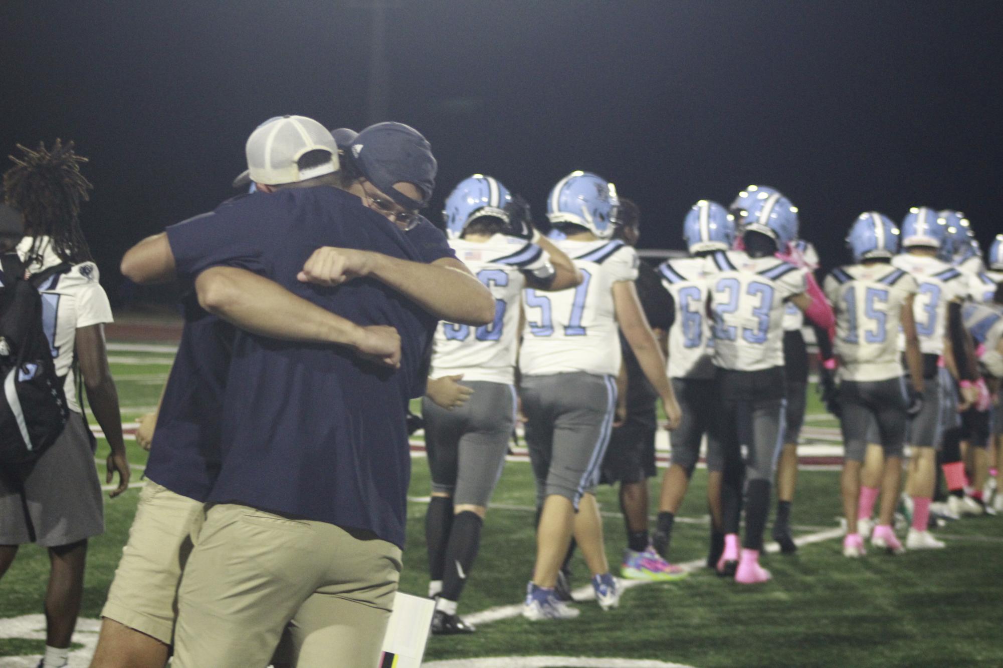 Jack Moss hugs another football coach after High beat West. Moss will be the new girls track coach