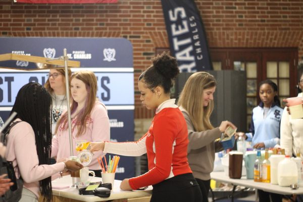 With total concentration, Sophomore Gyzell Whitehurst pours sweetener into Kennidi Criglers freshly made coffee. On Friday, Feb. 14, FCCLA held a coffee Friday, where they made coffees, and refreshers for the students.  