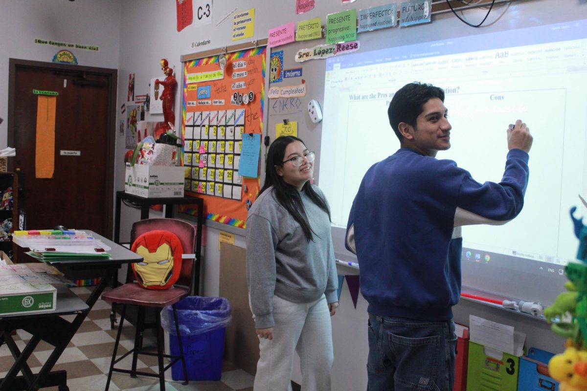 Sharing his ideas, Luis Alcantara (11) writes his thoughts on gentrification on the board with Rosaisela Cordero-Sanchez (11) by his side. The two made a presentation together talking about gentrification and how it affects the world today in Hispanic countries. They presented it during Hispanic Heritage Club in Señora Lopez-Reese’s room.