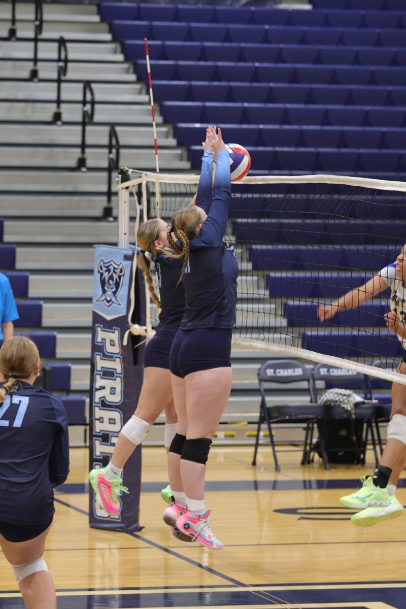 Violet Lewis and Rosie Kuegele blocking the ball on outside