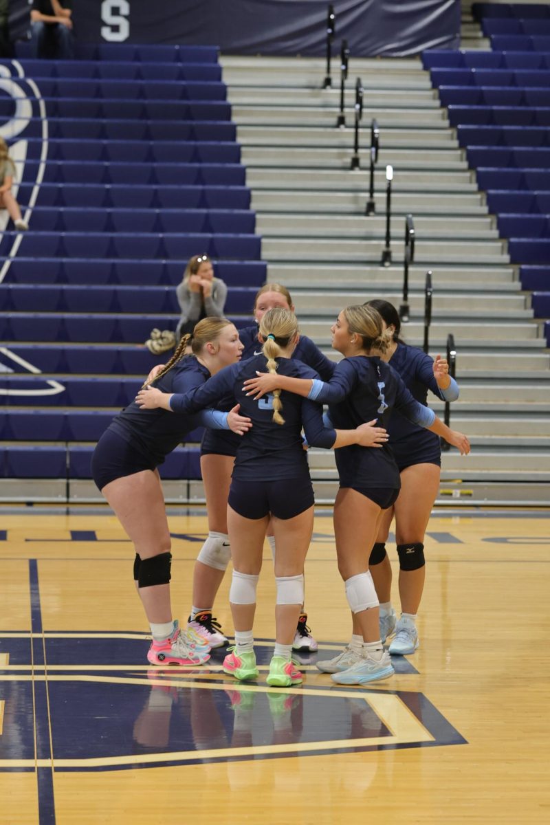 Varsity huddling in the middle to talk after a point