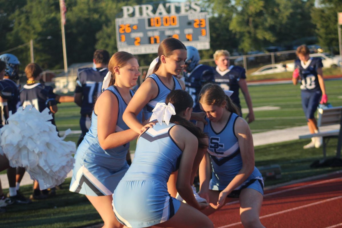Kenzie Warmann, Tempye Vilmaire and Madison Furlong get ready to fly Piper Riddle