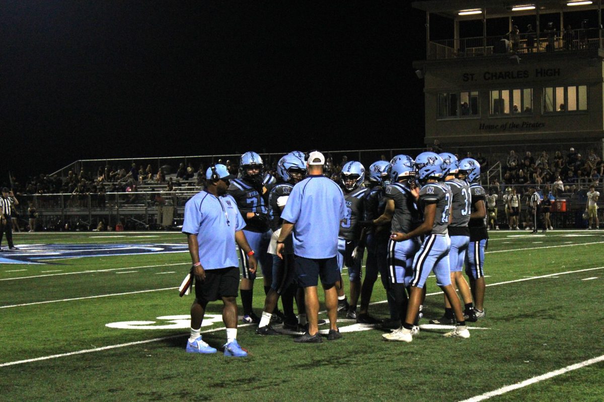 Head Coach McMullen strategizing with the Pirates in the huddle.