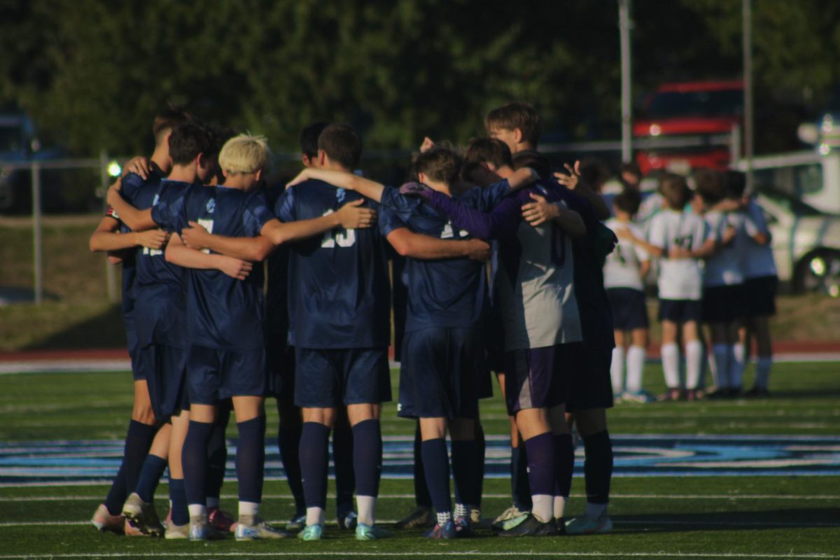 Boys Varsity Soccer team in a huddle.