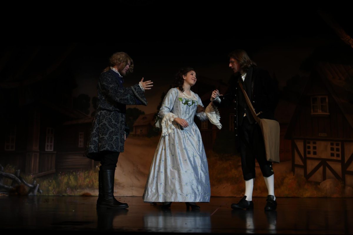 Katrina Van Tassel (Colleen Ney) talks to her suitors as they fight over her.