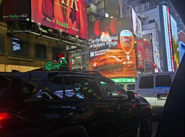 Newspaper mascot Vinny takes a ride on top of a car.