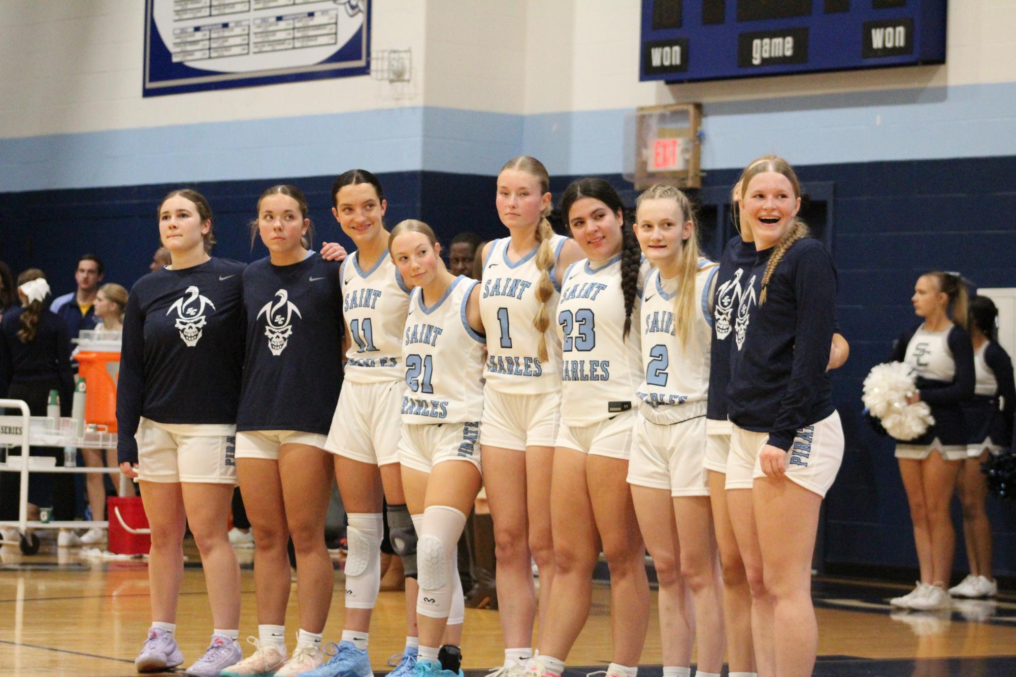 The girls basketball team gathers together for the national anthem before their game against St. Charles West. (Lucy Brodeur)