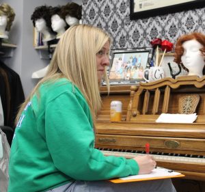 Courtney Gibson is sitting at her piano taking notes.