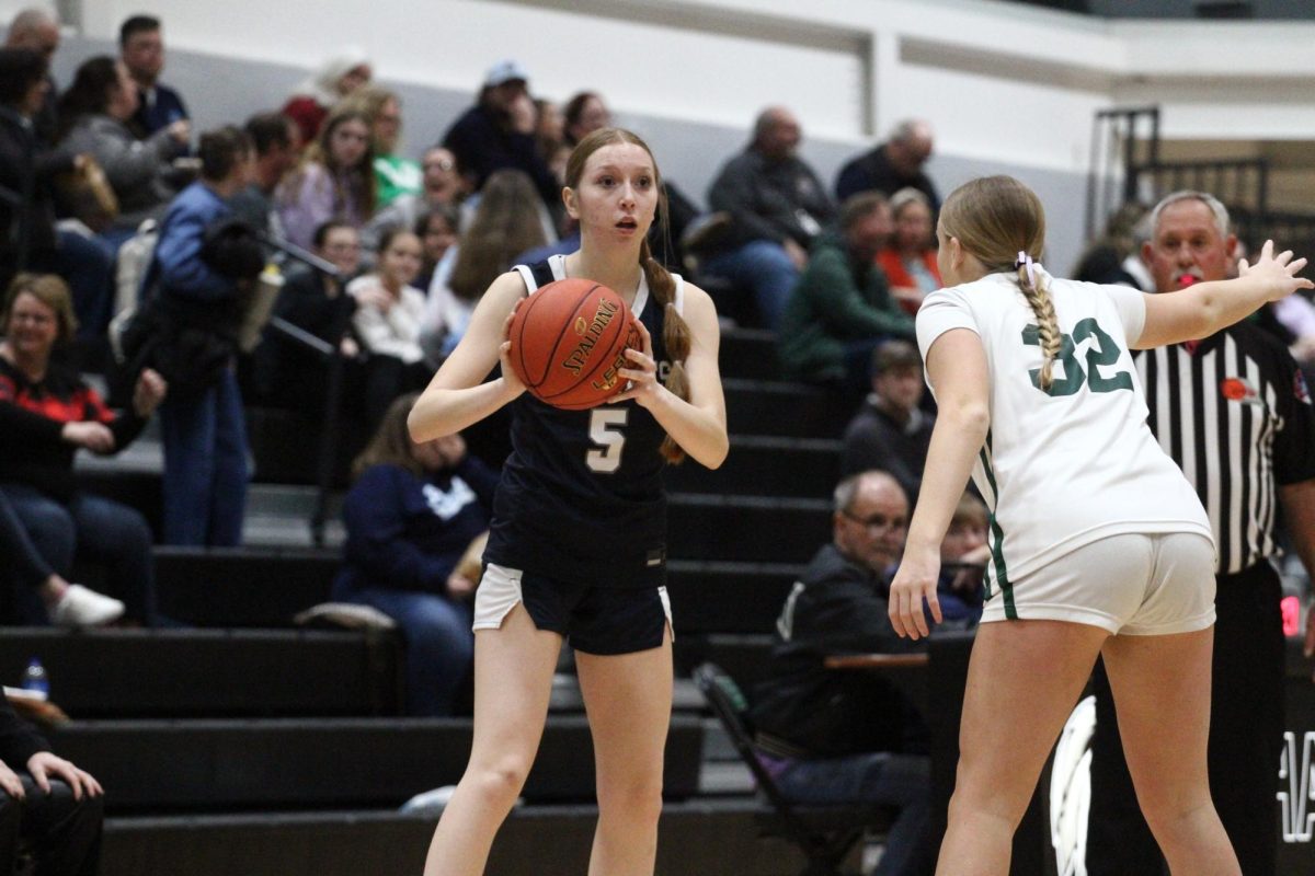 Addie Blair looks for an open teammate to pass the ball to during a basketball game against Orchard Farm.