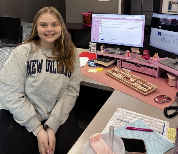 New attendance secretary Danielle Uskiwich smiling at the camera from behind the attendance office desk.