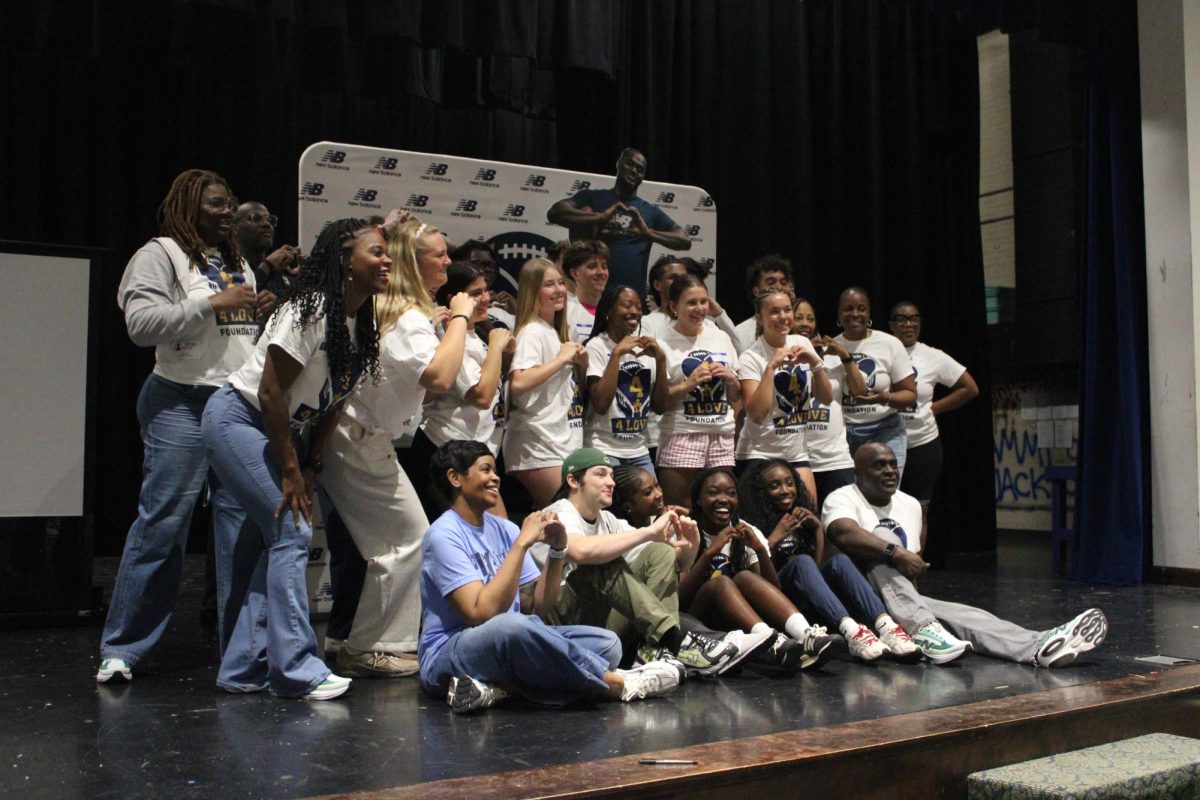 Students and Organizers pose for a photo in front of the media backdrop.
