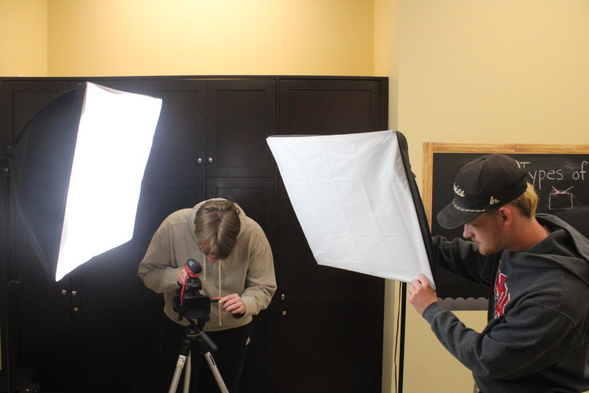 Aaron Tinker and Connor Murray adjust camera equipment.