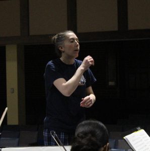 Orchestra Director Amanda Davis conducting her orchestra rehearsal.